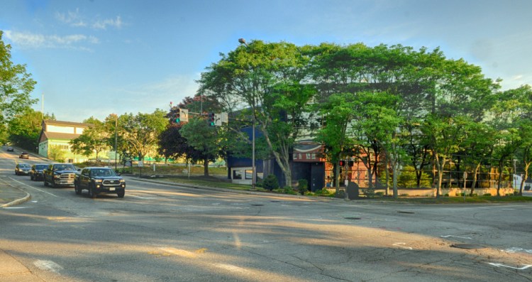 The Maine Public Employees Retirement System building, at right behind trees, seen July 19, and the former Department of Transportation building in background, both would be demolished to make way for new state office buildings and parking if a Virginia-based developer's proposal is approved.