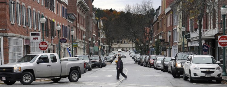 A woman walks across Water Street in Gardiner in 2014. The city will host a StoryWalk on Friday for children and their families, which includes walking in both directions along Water Street to read pages of the featured book, "My Name is Yoon," displayed in various businesses.