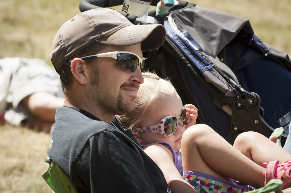 Scott McCormick, of Jackson, holds his daughter, Alice, 3, as they listen to musician being played at the East Benton Fiddle Convention on Sunday in East Benton.