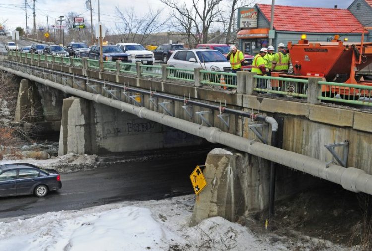 This Jan. 27 photo show Bridge Street bridge in Gardiner. The Maine Department of Transportation workers, at right, were there filling in potholes.