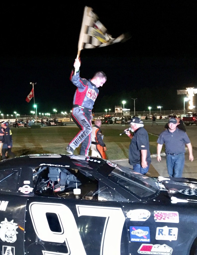 Joey Polewarczyk Jr. of Hudson, New Hampshire, celebrates with the checkered flag after winning the PASS 150 on Saturday night at Beech Ridge Motor Speedway in Scarborough.