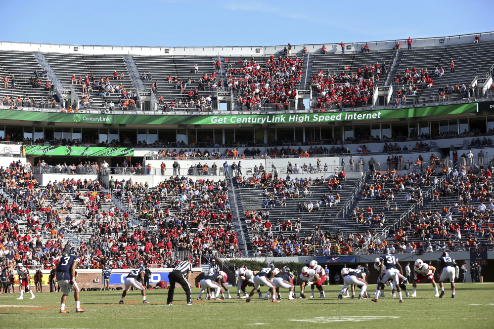 In this Oct. 29, 2016, file photo, Louisville lines up for a play against Virginia during a game in Charlottesville, Virginia. ESPN broadcaster Robert Lee will not work Virginia's season opener because of recent violence in Charlottesville sparked by the decision to remove a statue of Confederate Gen. Robert E. Lee. A spokeswoman for ESPN says Lee has been moved to Youngstown State's game at Pittsburgh on the ACC Network on Sept. 2. The network says the decision was made "as the tragic events in Charlottesville were unfolding, simply because of the coincidence of his name."