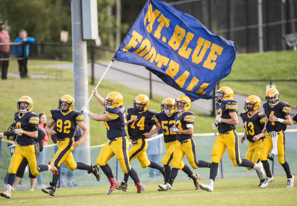 Members of the Mt. Blue High football team run onto Caldwell Field in Farmington prior to an Aug. 25 exhibition game against Nokomis.