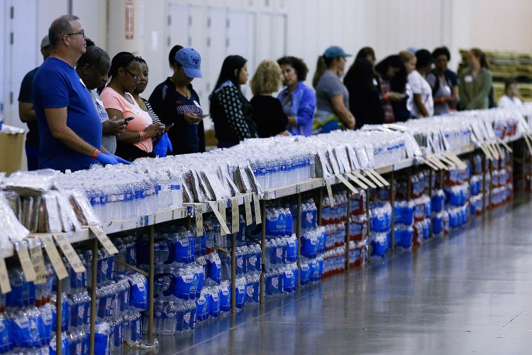Volunteers get ready to help at a food and water line at NRG Center, which opened its doors to evacuees in the wake of Harvey, on Wednesday in Houston. 