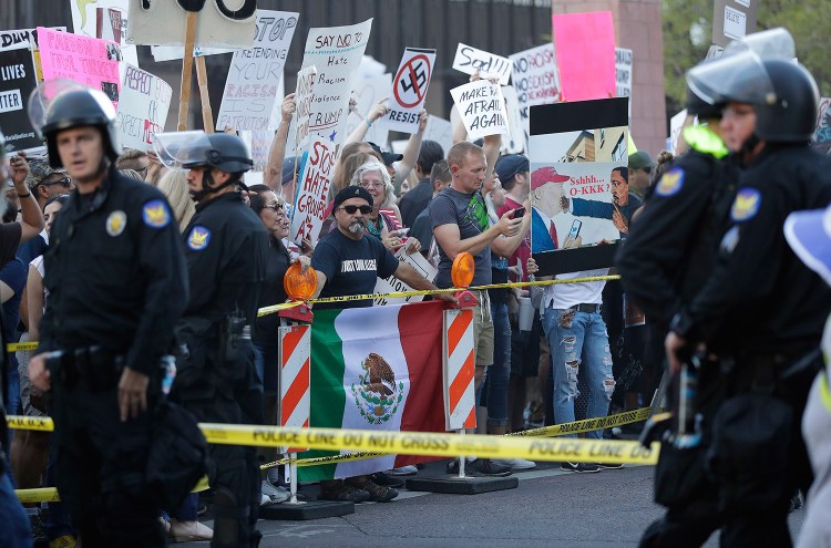 People protest outside the Phoenix Convention Center during his rally Tuesday night.