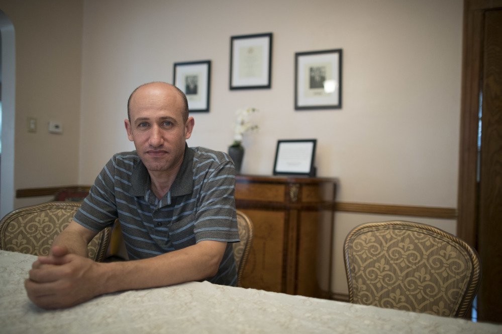 Ghassan al-Chahada, of Syria, poses for a portrait during an interview in the dinning room of President Trump's boyhood home. The house that Trump's father built is now a rental available on Airbnb.