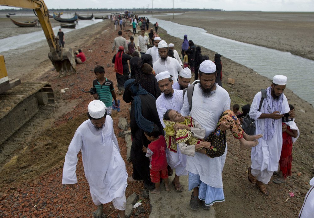 A Bangladeshi volunteer carries a newly arrived elderly Rohingya Muslim woman Sonabanu Chemmon and heads toward a camp for refugees in Teknaf, Bangladesh.
