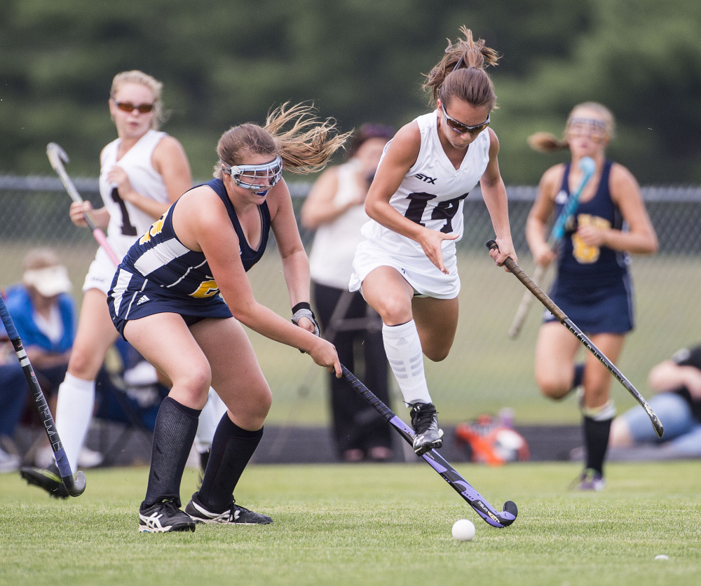 Skowhegan sophomore Alexis Michonski (14) leaps over the stick of Mt. Blue junior Jacelyn Daggett during the first half of a Kennebec Valley Athletic Conference Class A game Tuesday in Skowhegan.