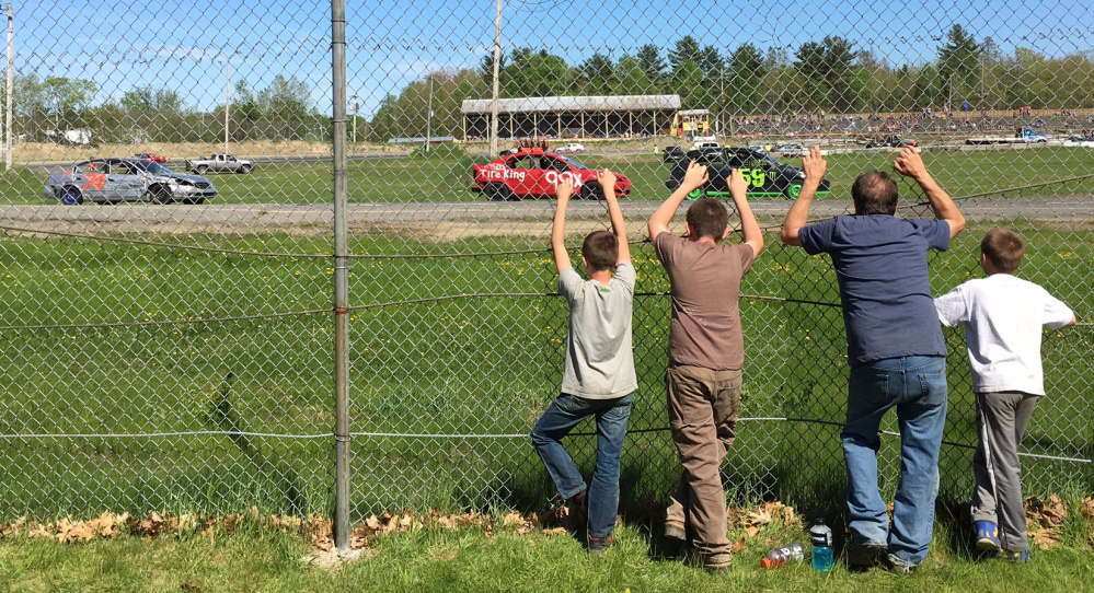 Fans stand against the pit area fencing to watch a race back in May at Unity Raceway in Unity.