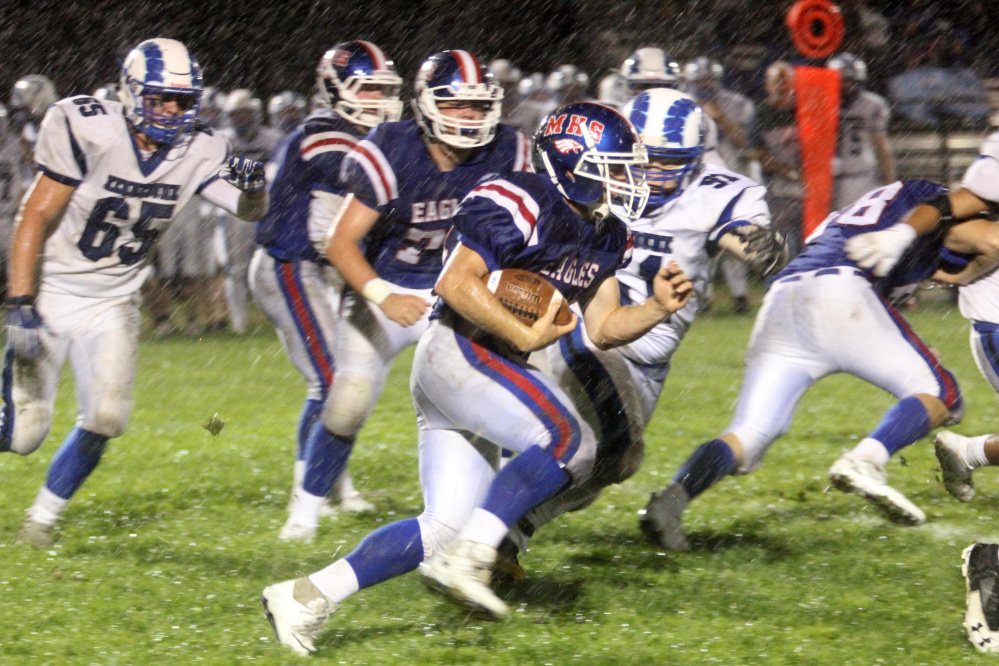 Messalonskee's Alden Balboni tries to elude a tackle by Kennebunk's Brede Gibson during first-half action in Oakland on Friday night.