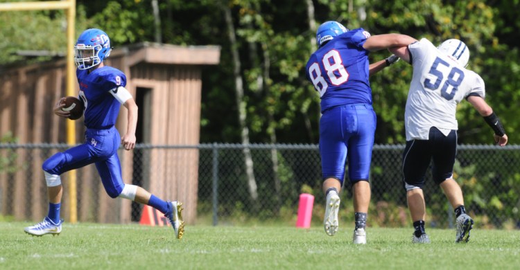 Oak Hill quarterback Gavin Rawstron, left, runs as Austin Pierce (88) blocks Yarmouth defensive lineman Hunter Harrington during their game on Saturday at Oak Hill High School in Wales.