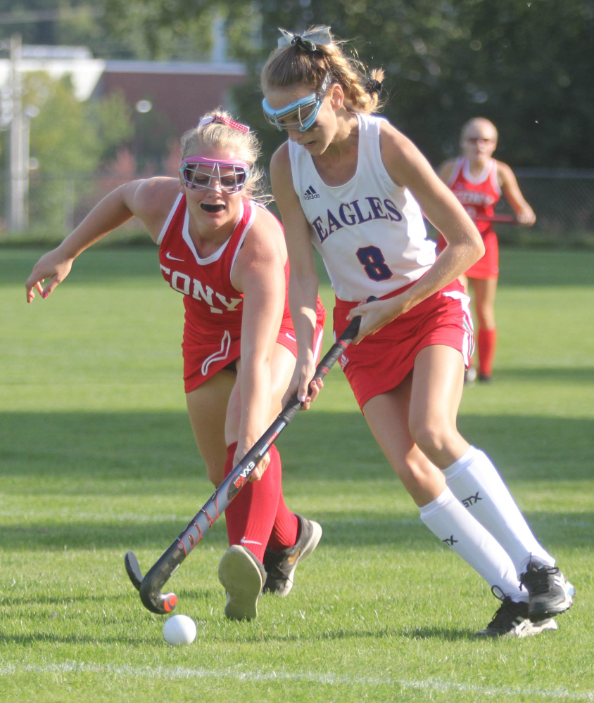 Cony High School's Alexis Couverette, left, lunges to try and take the ball from Messalonskee High School's Megan Quirion during first-half action in Oakland on Thursday.