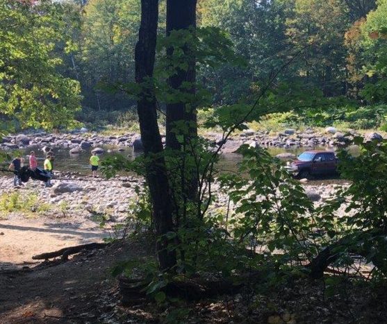 Games wardens and sheriff's deputies investigate a Chevrolet pickup truck that was abandoned Sunday morning in the Carrabassett River in New Portland. The truck's owner was charged by police with leaving a submerged vehicle in a waterway.