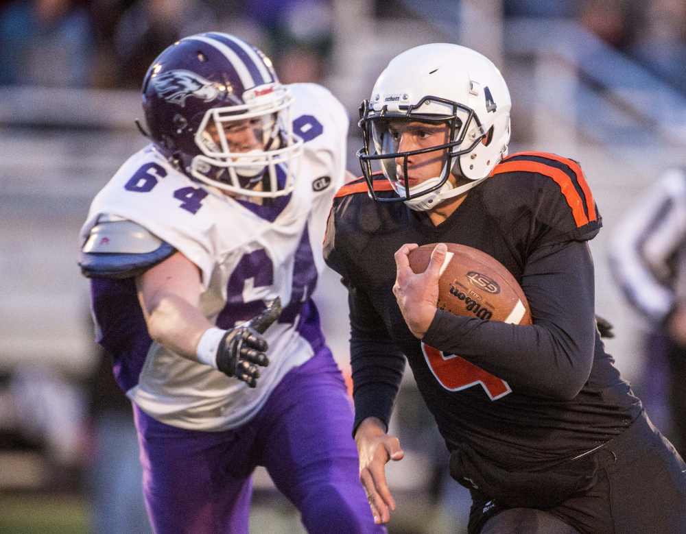 Skowhegan quarterback Marcus Christopher, right, scrambles away from Marshwood junior defender Adam Doyon during a Class B game earlier this season in Skowhegan.