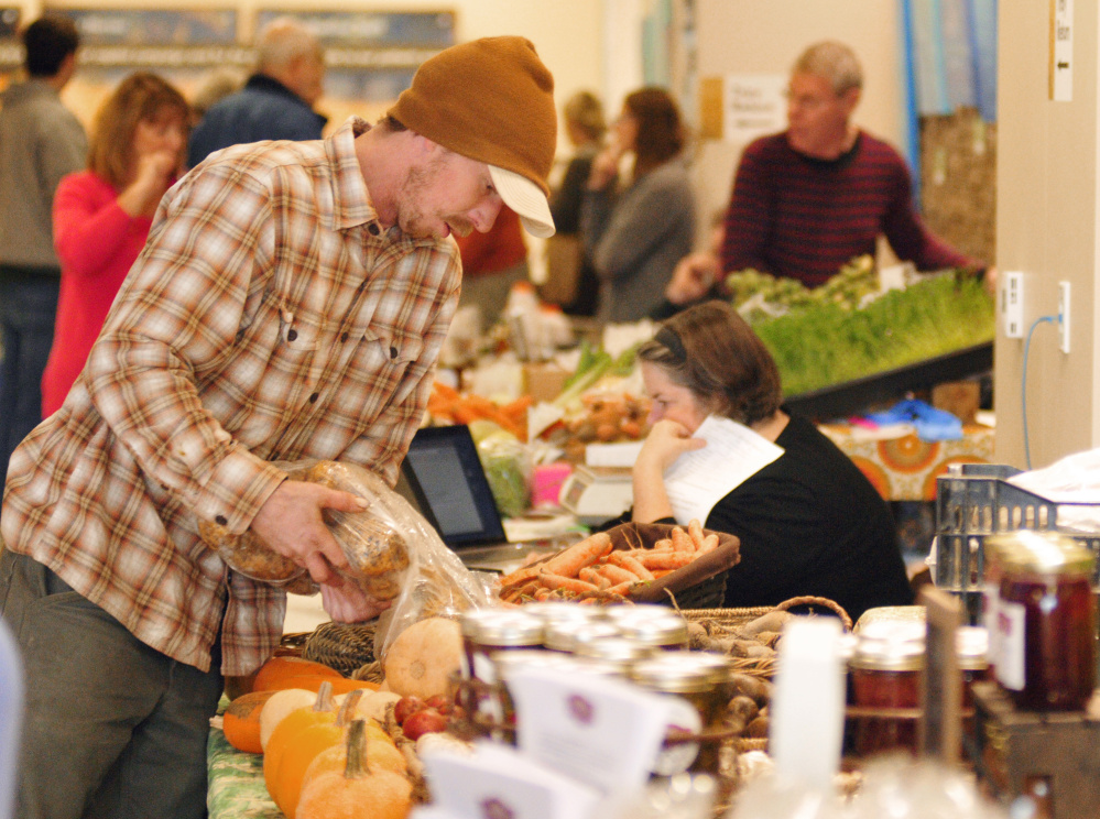 Eric Snow sets up the Grassland Organic Farms booth on Dec. 13, 2016 for the Farmers' Market at Mill Park winter location in the MaineGeneral Medical Center in Augusta. City council will meet tonight to discuss a location for the market on State Street in the city.