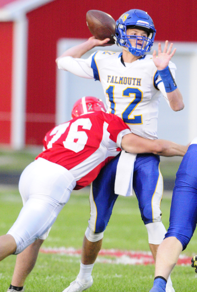 Cony defensive end Nic Mills hits Falmouth quarterback Jack Bryant during a Class B game earlier this season at Alumni Field in Augusta.