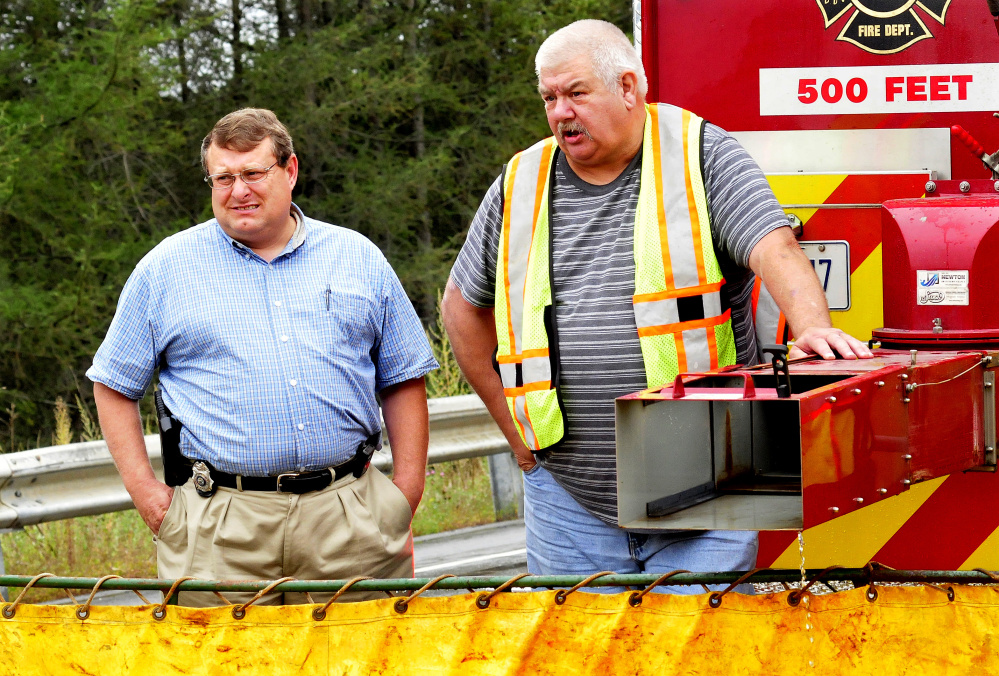 Office of State Fire Marshal investigator Joel Davis, left, speaks with a firefighter Sept. 18 at the scene of a house fire at 230 Lakeview Drive in South China. Rebecca Poulin, who occupied the house with her husband, Philip Poulin, has been charged with arson.