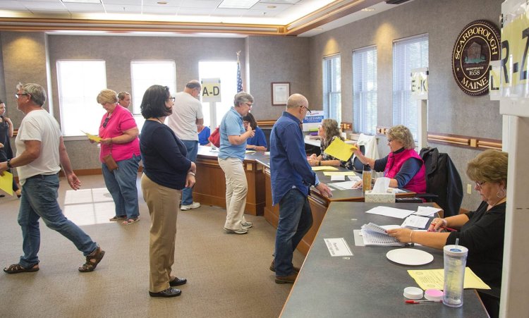 In Tuesday's referendum on the school budget, Scarborough residents pick up ballots before voting at the town hall. Left out of the initial vote count were 420 ballots.