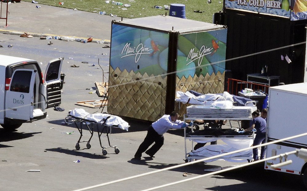 Investigators load bodies from the scene of the mass shooting at a music festival near the Mandalay Bay resort and casino on the Las Vegas Strip on Monday.