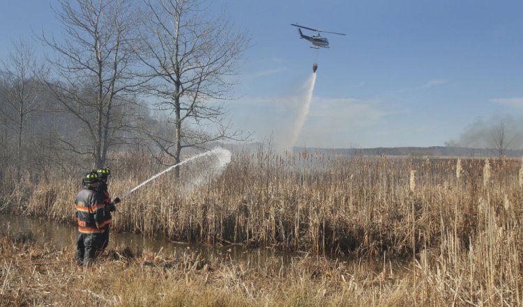 Firefighters battle a brush fire in Old Orchard Beach on April 15, 2016, that was fanned by strong wind. Ricky Plummer, who was the town's fire chief at the time, pleaded guilty Wednesday to setting the fire.