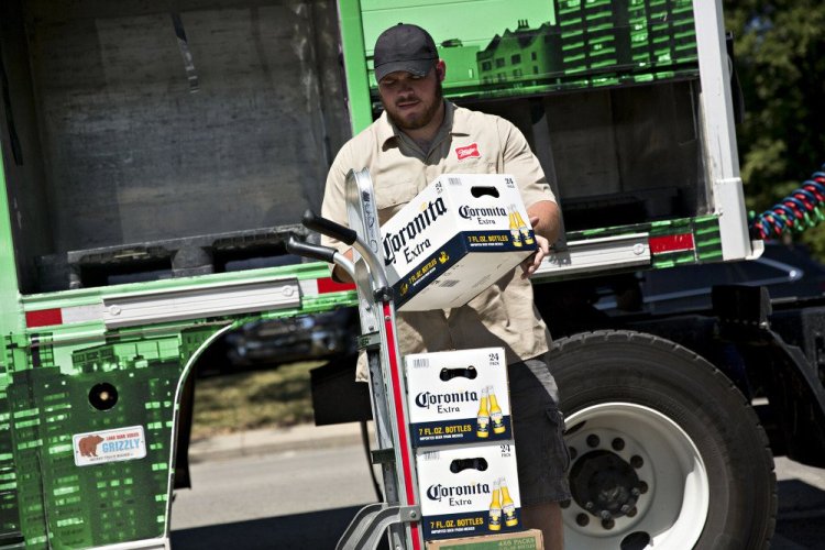 A worker loads cases of Constellation Brands' Corona beer onto a cart for delivery in Ottawa, Illinois, on June 27, 2017. (MUST CREDIT: Daniel Acker/Bloomberg)