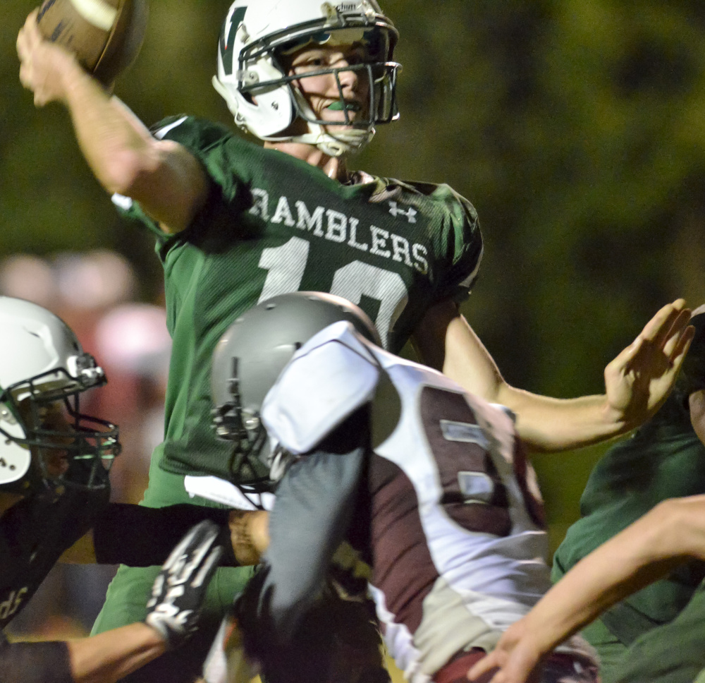 Winthrop/Monmouth quarterback Keegan Choate gets off a pass under pressure from Ellsworth' defender Dante Cross during a Class D game last week at Maxwell Field in Winthrop.