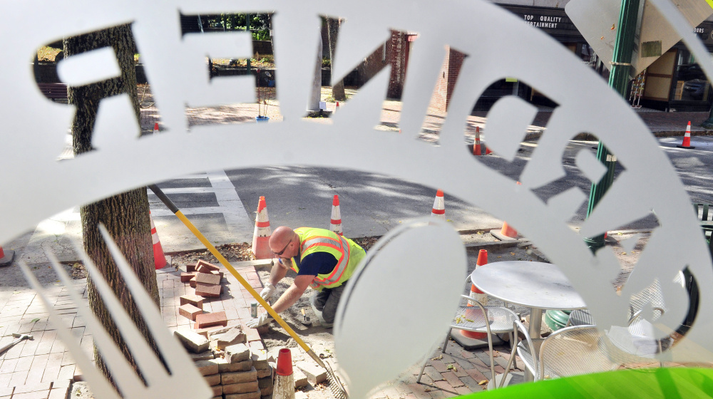 City worker Dan Robideau rebuilds the brick sidewalk in front Gardiner Co-op on Tuesday on Water Street in Gardiner.