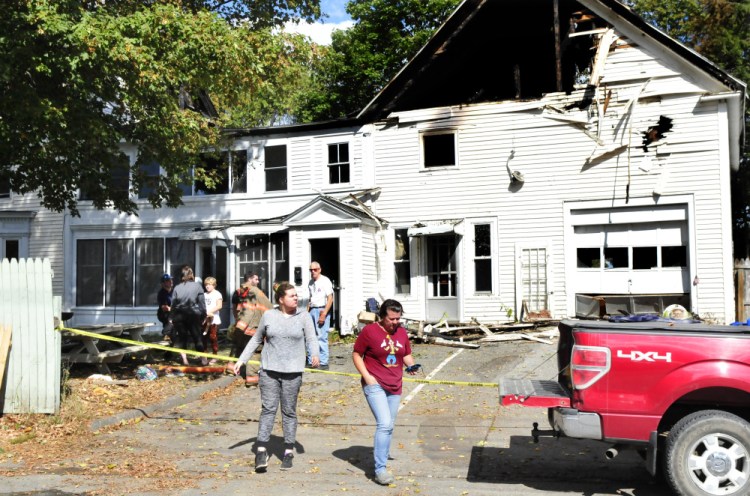 On Monday apartment tenants Christiane Pomeroy, right, and her daughter Abbigale Harris leave the scene of a fire that destroyed a home Sunday in Pittsfield. The couple said they had just moved out last weekend and still had belongings in the home.