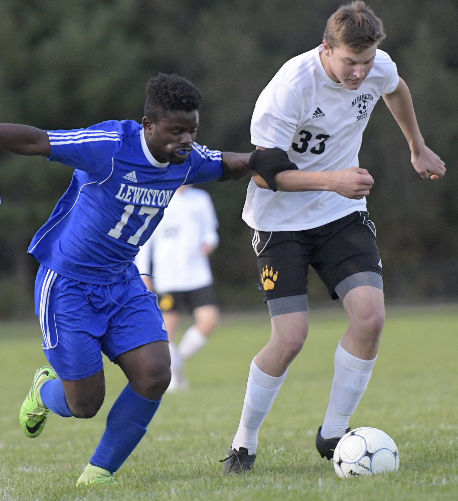 Maranacook's Riley Maddocks, right, is grabbed by Lewiston's Henok Citenga during a Kennebec Valley Athletic Conference game Tuesday in Readfield.