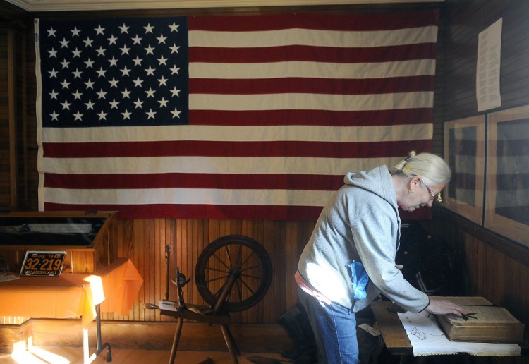 Linda Cobb unfolds a Bible on Sept. 24, 2015, at the Manchester Grange, which is celebrating its 150th birthday on Sunday.