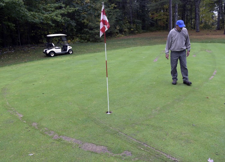 Ruts from golf carts surround Bill Sylvester on the second green at Cobbossee Colony Golf Course in Monmouth on Monday. The Sylvester family discovered Monday that several parts of their course were vandalized by golf carts overnight.