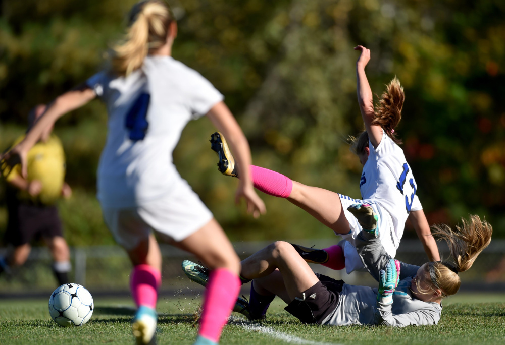 Erskine sophomore Morgan Presby (13) collides with Waterville goalie Aly Drew during a Class B North game Friday in South China.