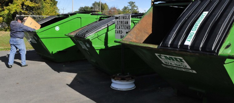 Winslow resident John Perry deposits recyclable material in one of the bins at the Winslow Public Library on Monday. Anecdotally, most who bring their recycling to the bins are regulars. The town has hoped that more people would participate in the pilot program.