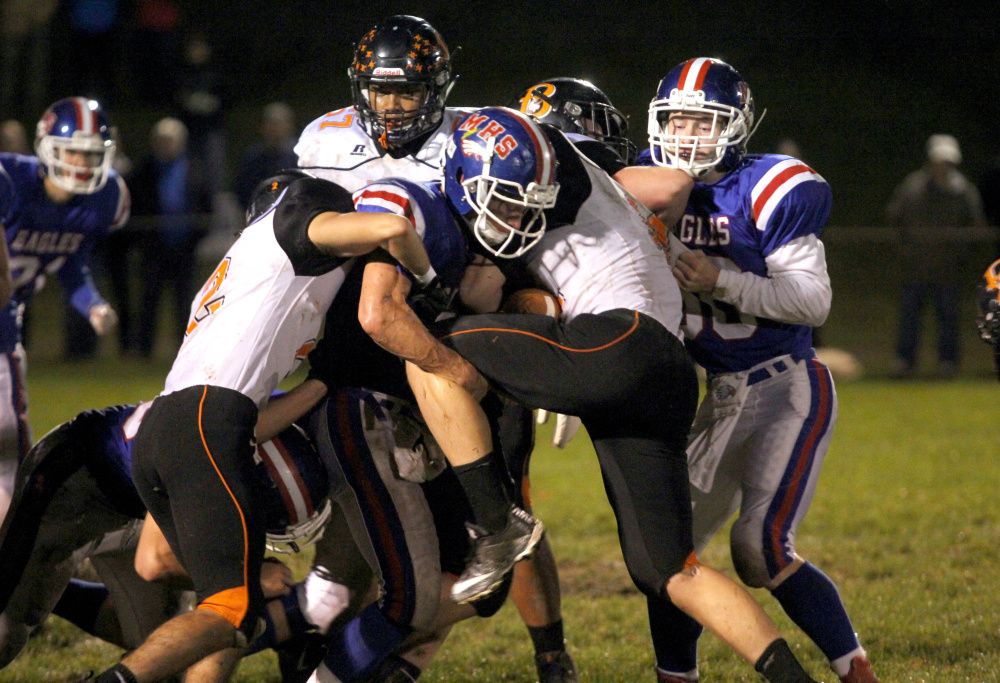 Messalonskee High School's Tyler Lewis wraps up Brewer's Andrew Kiley during first-half action in Oakland on Friday night.