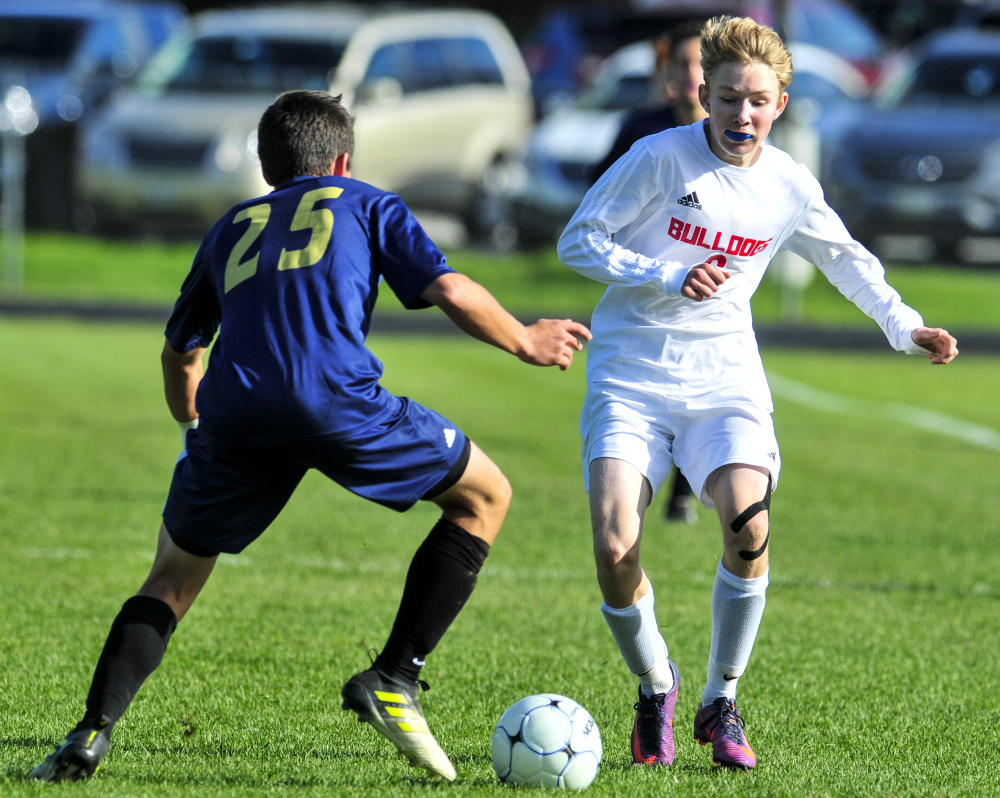 Traip's Connor Reed (25) tries to stop Hall-Dale's Ian Stebbins during a Class C South semifinal Saturday in Farmingdale.