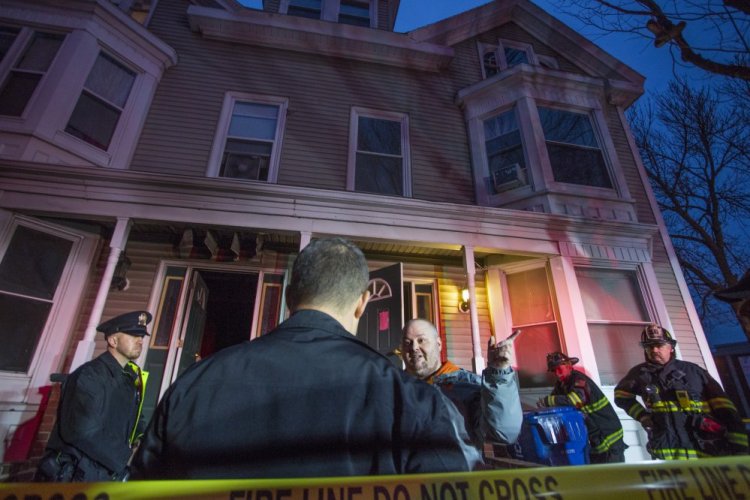 Peter Sullivan talks with investigators at the scene of a fire at 3 Sherman St. in Portland on Tuesday afternoon after a fire started in his apartment. Sullivan said he had to climb out his bedroom window to escape.