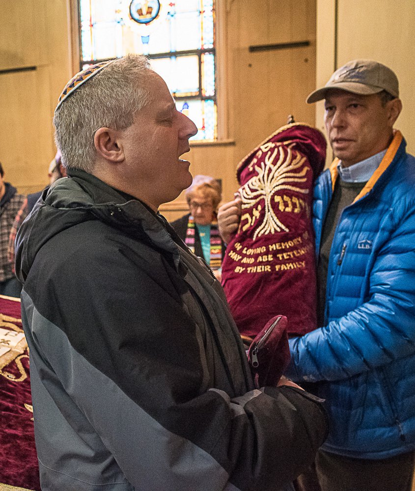 Rabbi Sruli Dresdner and Jamie Isaacson perform the deconsecration at Beth Abraham Synagogue in Auburn Sunday. The Torah, held by Isaacson, right, moved to Temple Shalom.