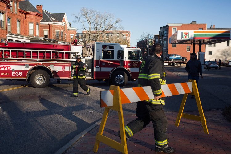 Firefighters begin to clear the road blocks on Congress street just past State Street after a car accident involving a SUV. The man driving the SUV crashed after passing out at the wheel due to a medical emergency. 