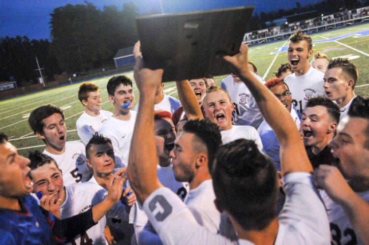 The Richmond boys soccer team celebrates with the plaque emblematic of the Class D South championship Thursday at McMann Field in Bath.