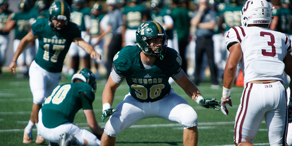 Husson kicker Devin Pickett prepares to attempt a field goal as Luke Washburn, front, prepares to block a defender during a game earlier this season in Bangor.