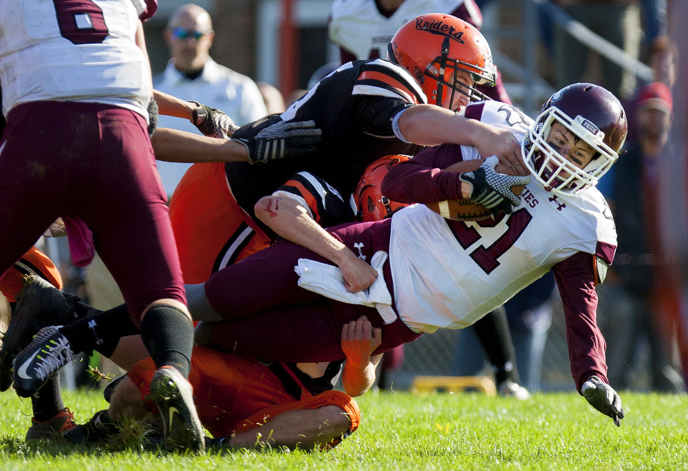 Winslow's Isaiah Goldsmith, center, brings down Maine Central Institute's Will Russell during a Class C North semifinal game last Saturday at Poulin Field in Winslow.