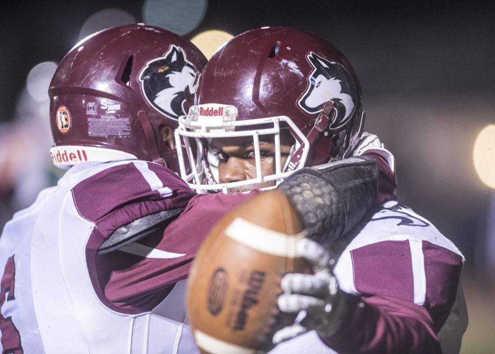 Maine Central Institute's Pedro Matos, right, celebrates his first quarter touchdown against Mt. Desert Island with teammate Adam Bertrand during the Class C North title game Saturday night in Bar Harbor.
