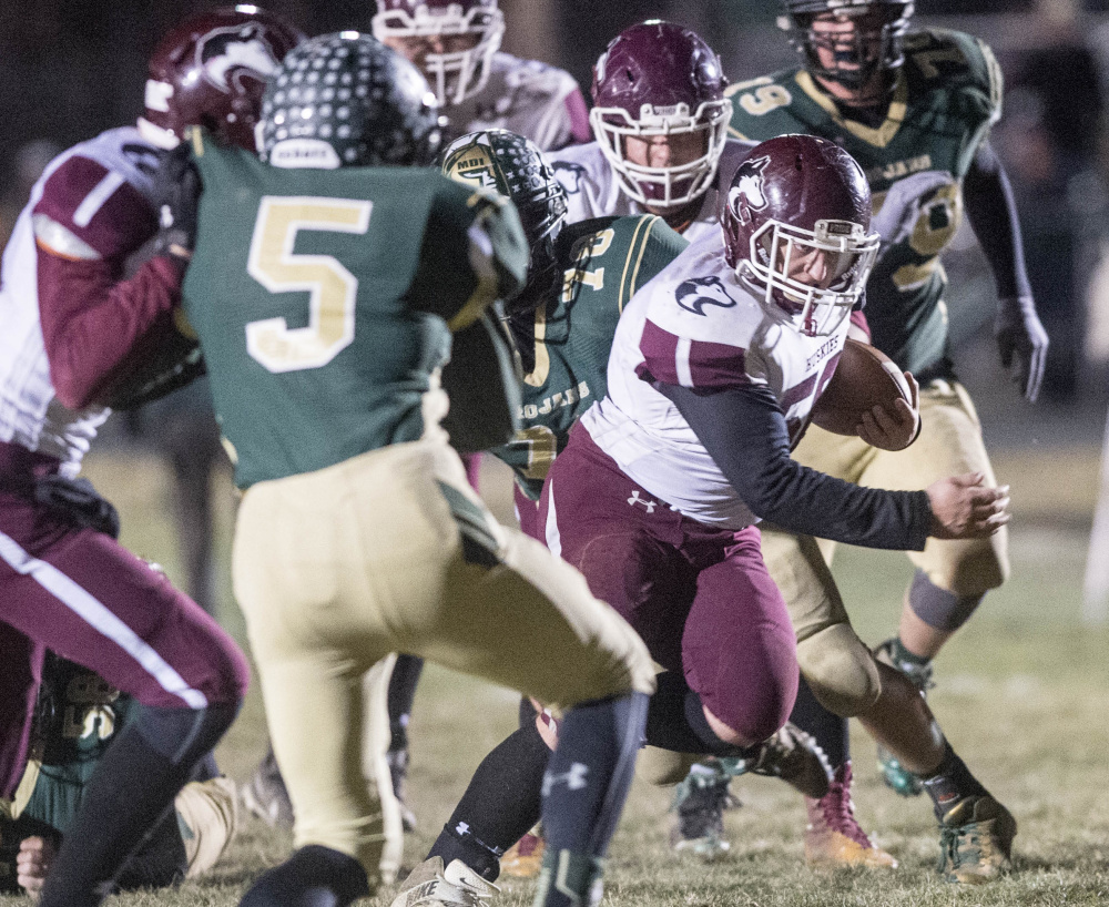 Maine Central Institute's Seth Bussell runs through the Mt. Desert Island line during the Class C North championship game Saturday night in Bar Harbor.