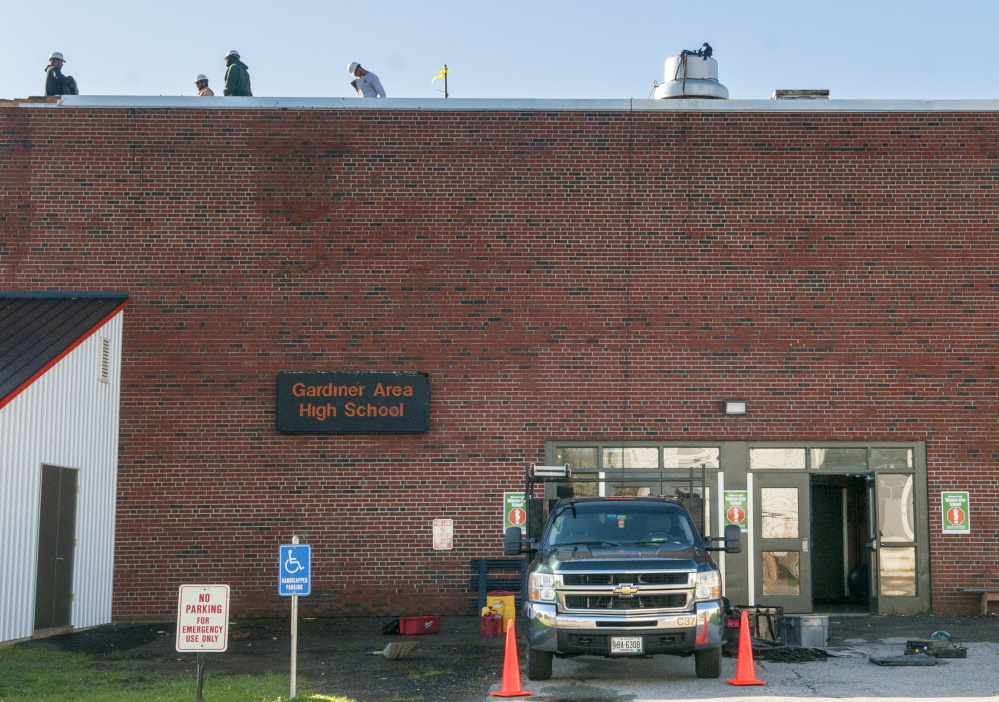 Workers from G&E Roofing tend to the wind damaged roof of the James A Bragoli Memorial Gym at Gardiner Area High School on Oct. 31.