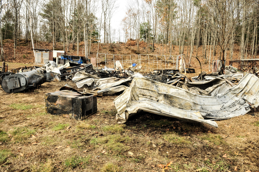 Fire destroyed this garage early Tuesday morning on Hunts Meadow Road in Whitefield. Firefighters pulled it down with an excavator to expose any remaining fire, which is why the metal roof and other items are spread around the yard.