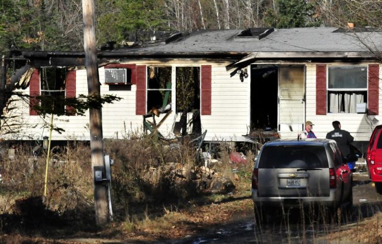 An investigator with the Office of State Fire Marshal, center, speaks with two men Wednesday outside a modular home on Pease Hill Road in Anson that a fire destroyed that morning.
