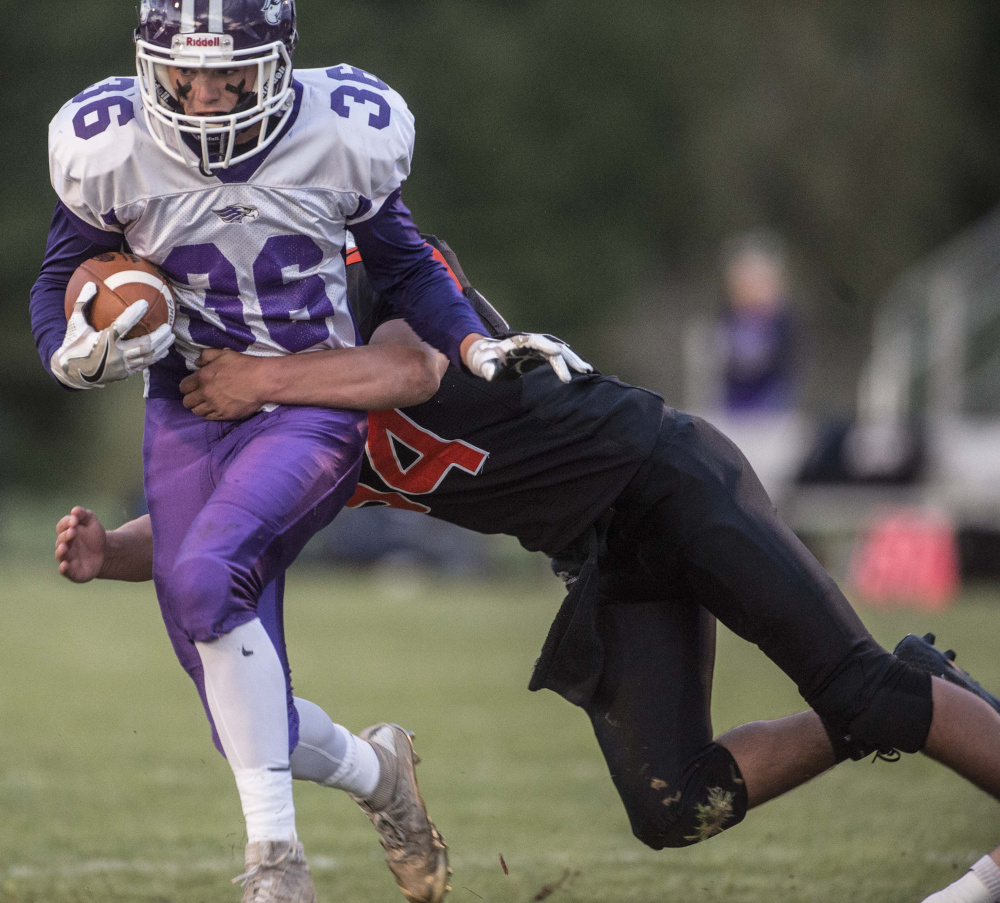 Marshwood's Kyle Gladden (36) is tackled by Skowhegan defender Kobe Houghton in the season opener Sept. 1 in Skowhegan.
