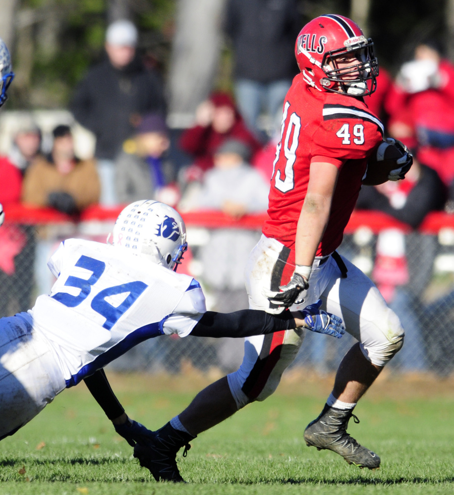 Madison's Jacob Meader, left, dives but misses Wells ball carrier Nolan Potter during the Class D South title game last Saturday in Wells.
