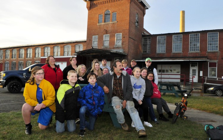 Ray Breton, front, owner of The Olde Mill Place in Vassalboro, is surrounded by volunteers Tuesday while talking about the effort to raise $250,000 to repair roof damage caused by an Oct. 30-31 wind storm.