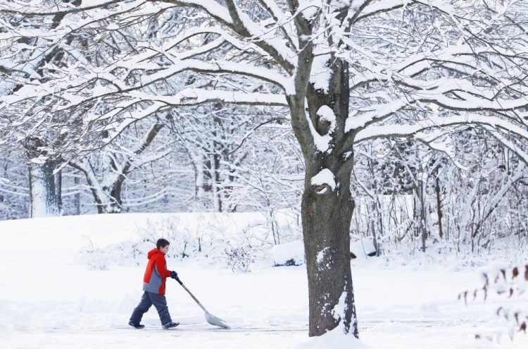 Gavin Brayne, 10, clears his driveway along Rogers Road in Kittery early Sunday following the first snowfall of the season.